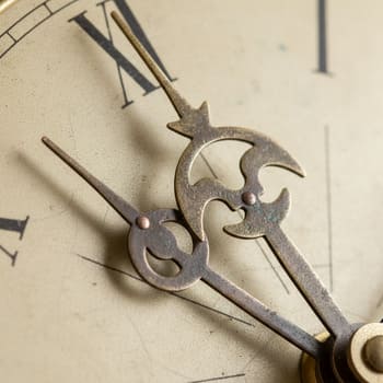 Close-up of clock hands with counterweights